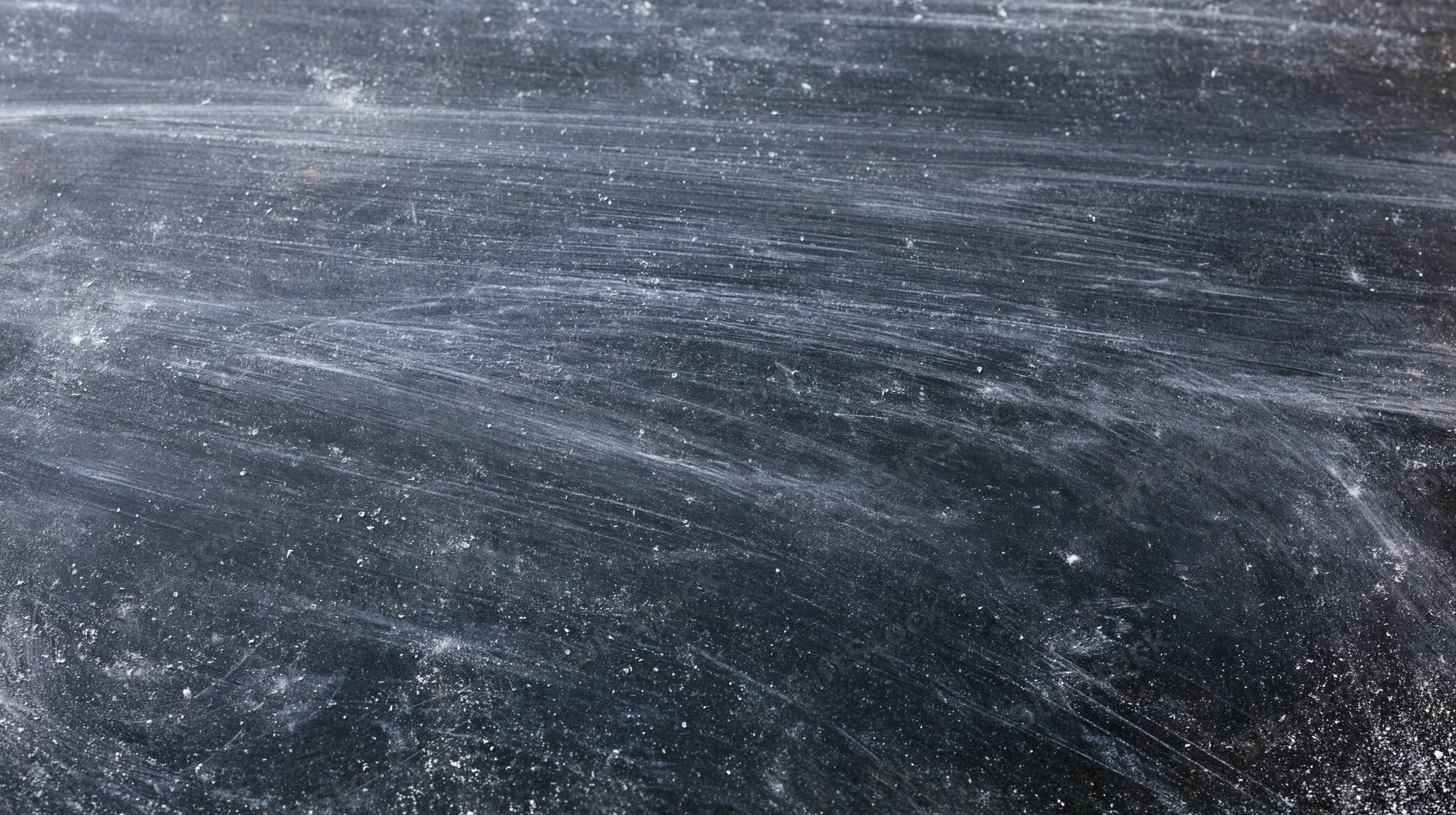 Worn blackboard surface with chalk residue and smudges, close-up view