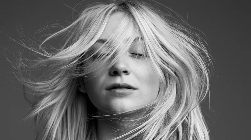 Young woman with long blonde hair swept across her face in a studio portrait