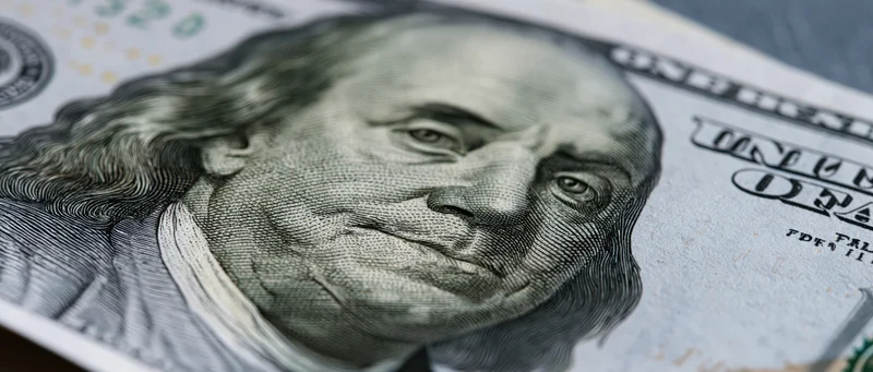 Closeup of a us hundred dollar bill showing benjamin franklin's portrait and security features