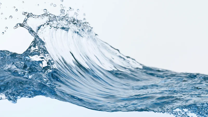 Dynamic water splash forming a curling wave against a white background