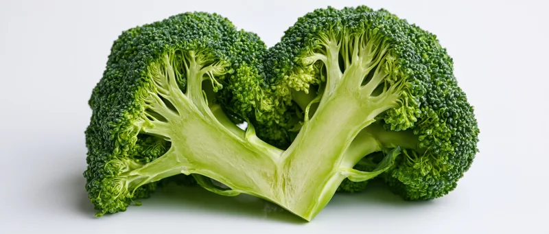 Two broccoli halves arranged in heart shape on white background