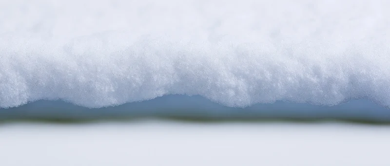 Closeup of a horizontal ridge of freshly packed snow against a blurred background