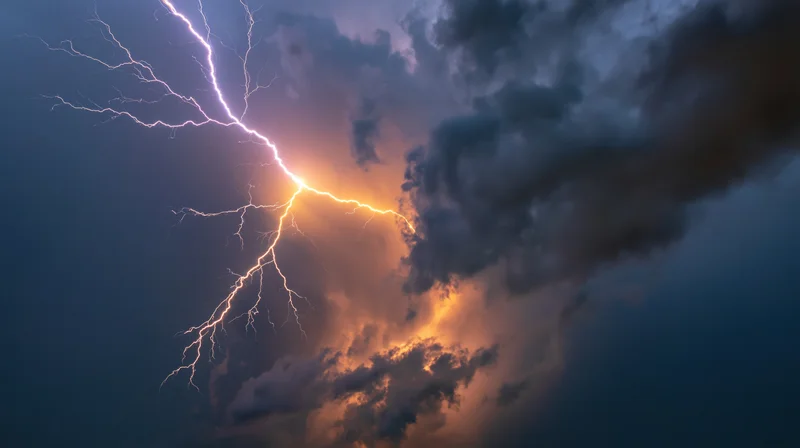 Jagged lightning bolt branching across stormy night sky with dark clouds and glowing edges