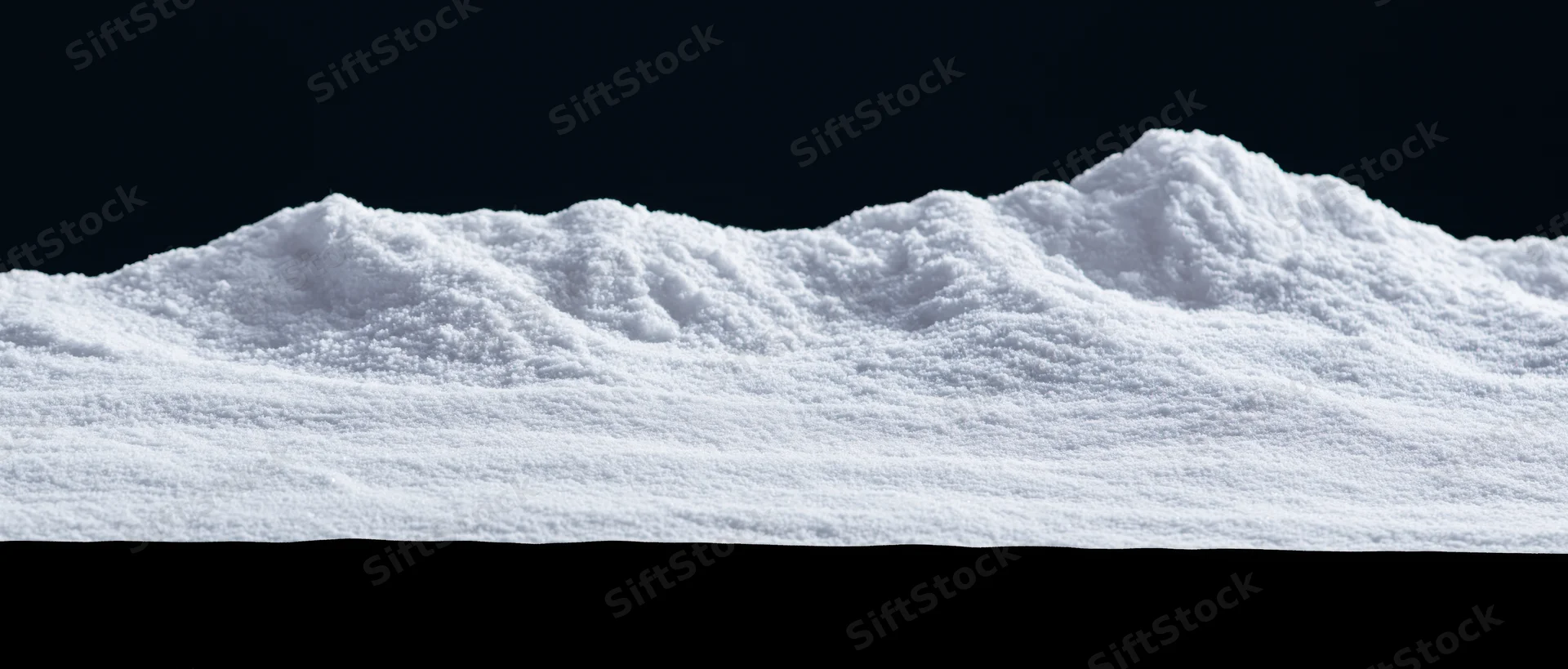 Low snow drift with uneven ridgeline against dark sky