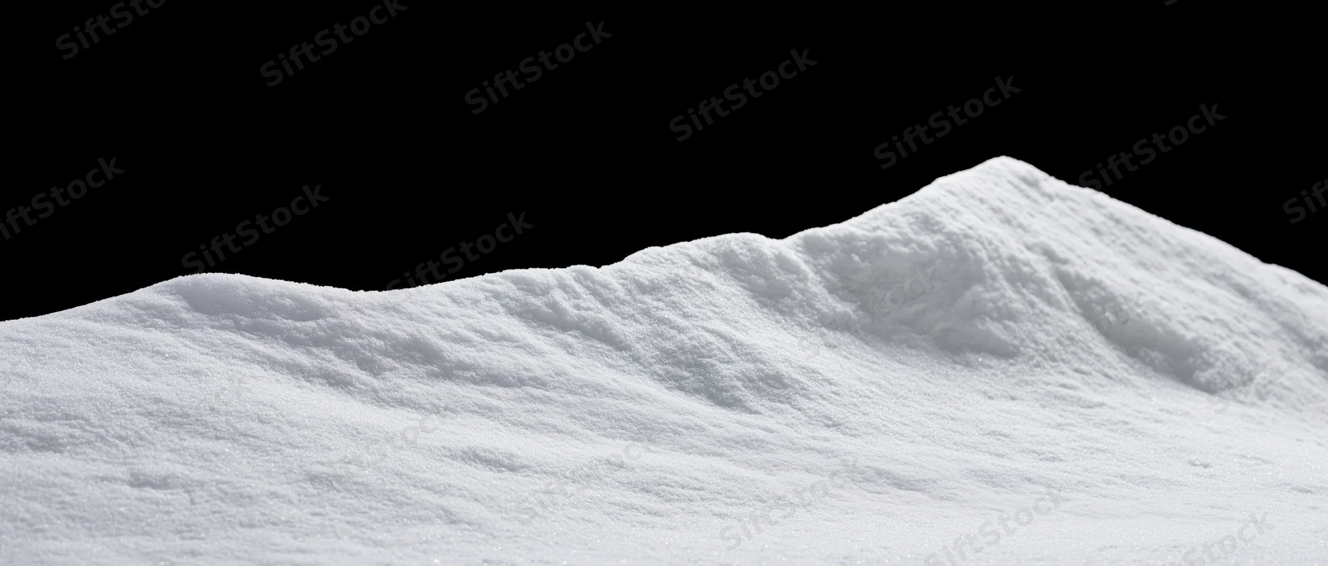 Low snow drift with gently uneven ridgeline against black background