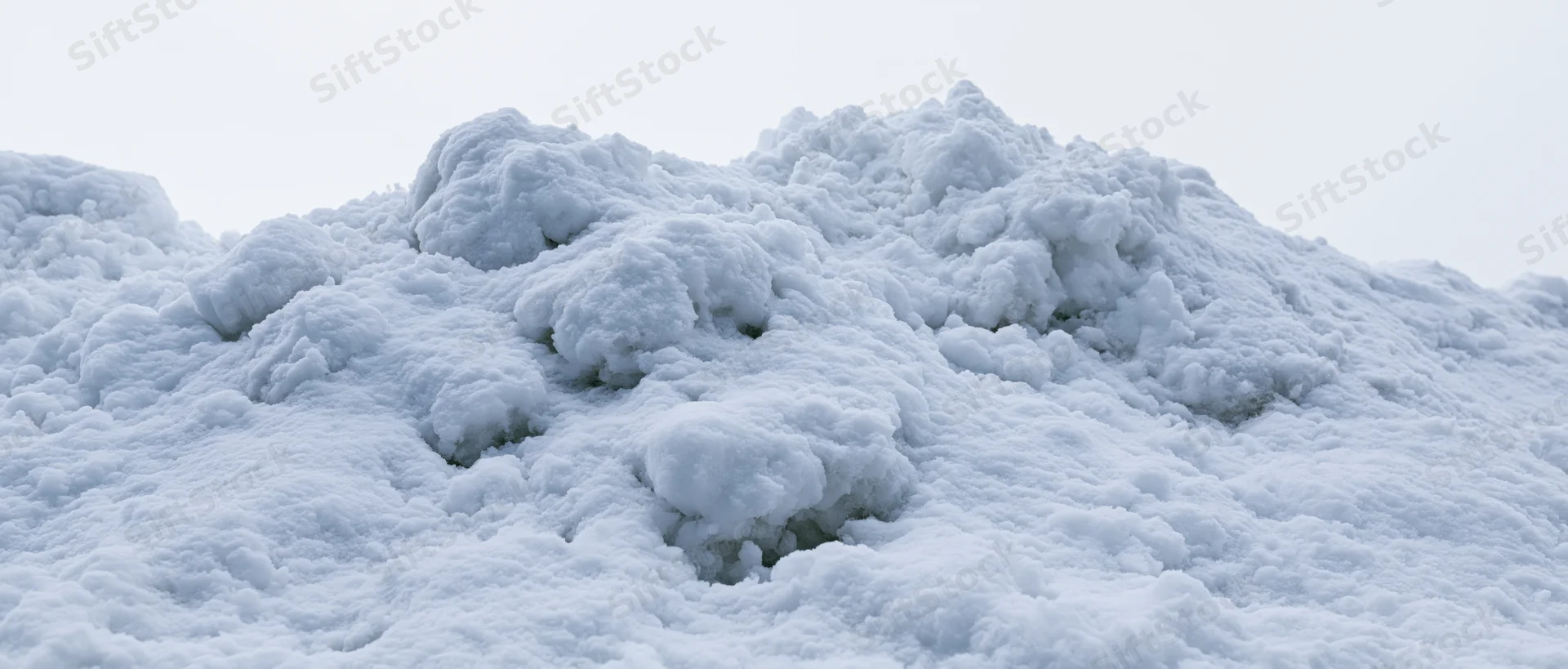 Close-up of a freshly piled snow mound outdoors under overcast sky
