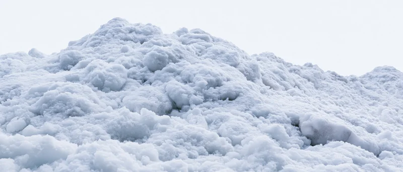 Close-up of a freshly piled snow mound under overcast sky