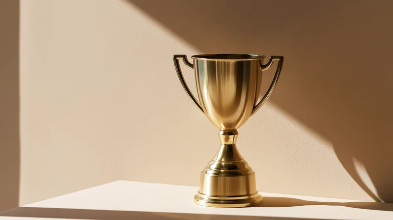 Polished gold trophy cup on a flat surface with soft shadows and warm light