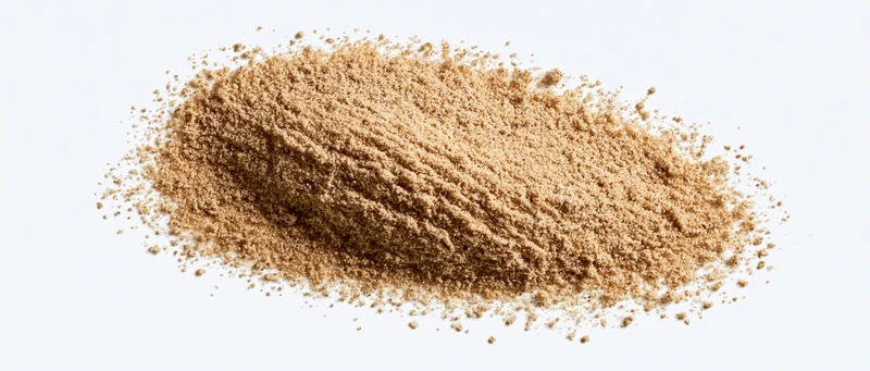 Fine desert sand piled in an elongated shape on a white background