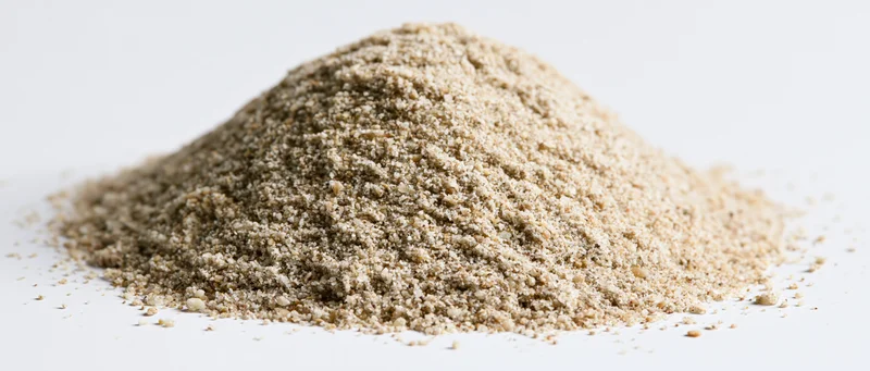 A mound of dry beach sand on a white surface