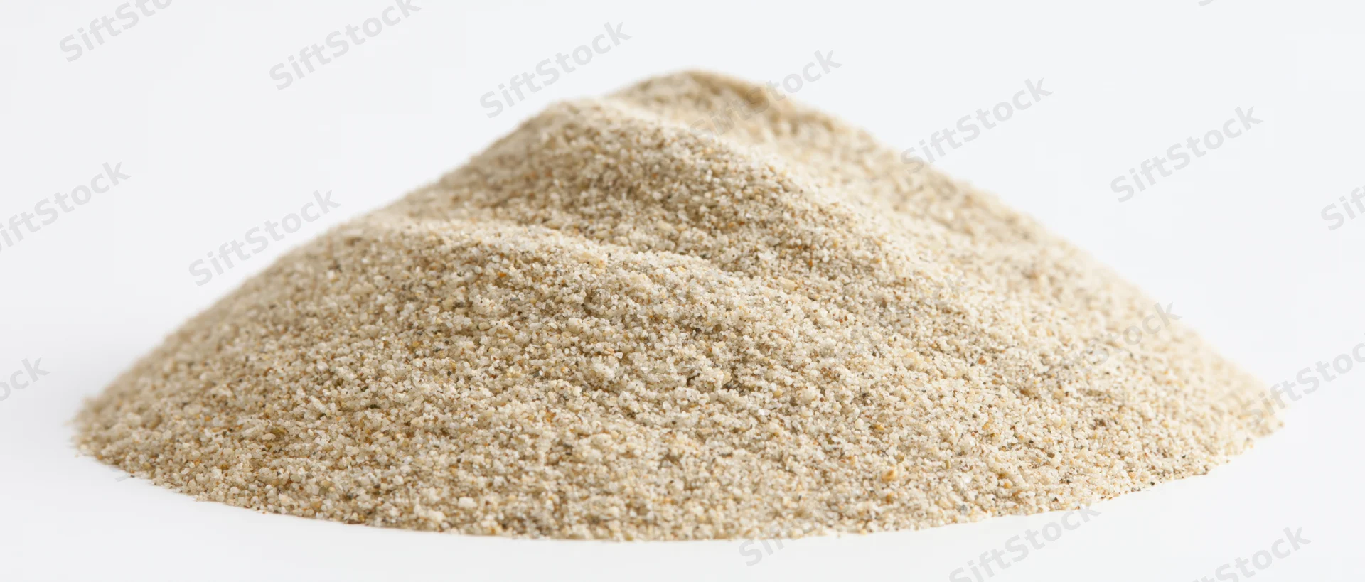 A heap of fine dry beach sand on a white background
