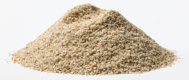 A heap of dry fine-grained beach sand on a white background