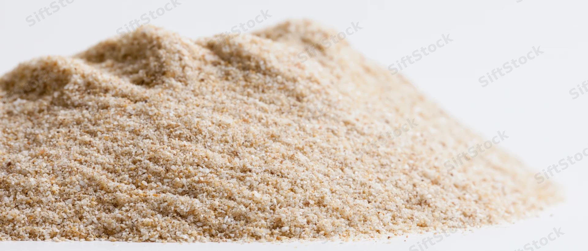 A heap of fine dry beach sand on a white background