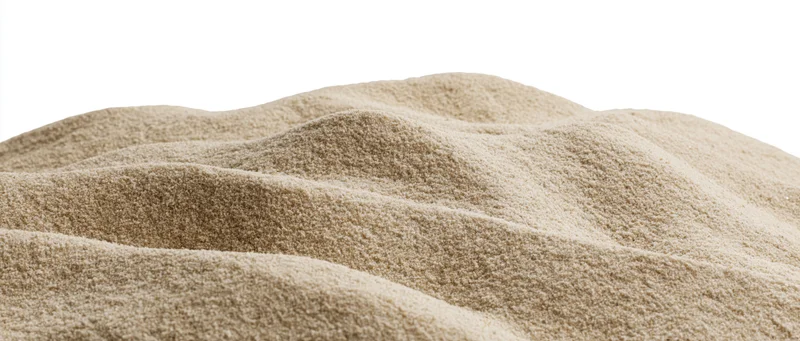 Mound of dry beach sand with undulating surface isolated on white