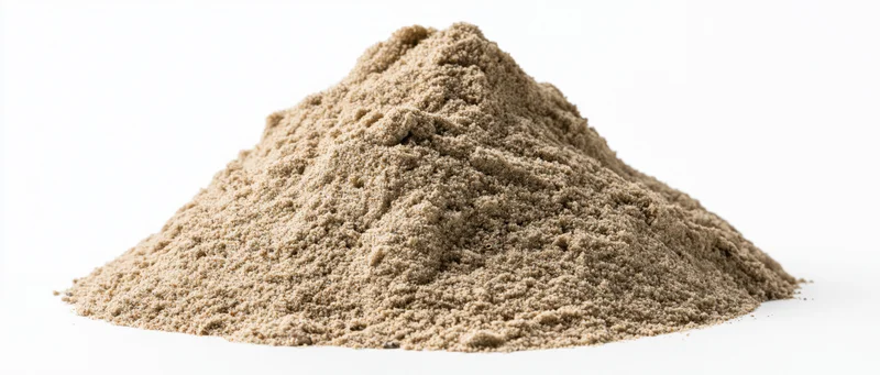 A pile of dry desert sand with natural ridges and peaks on a white background