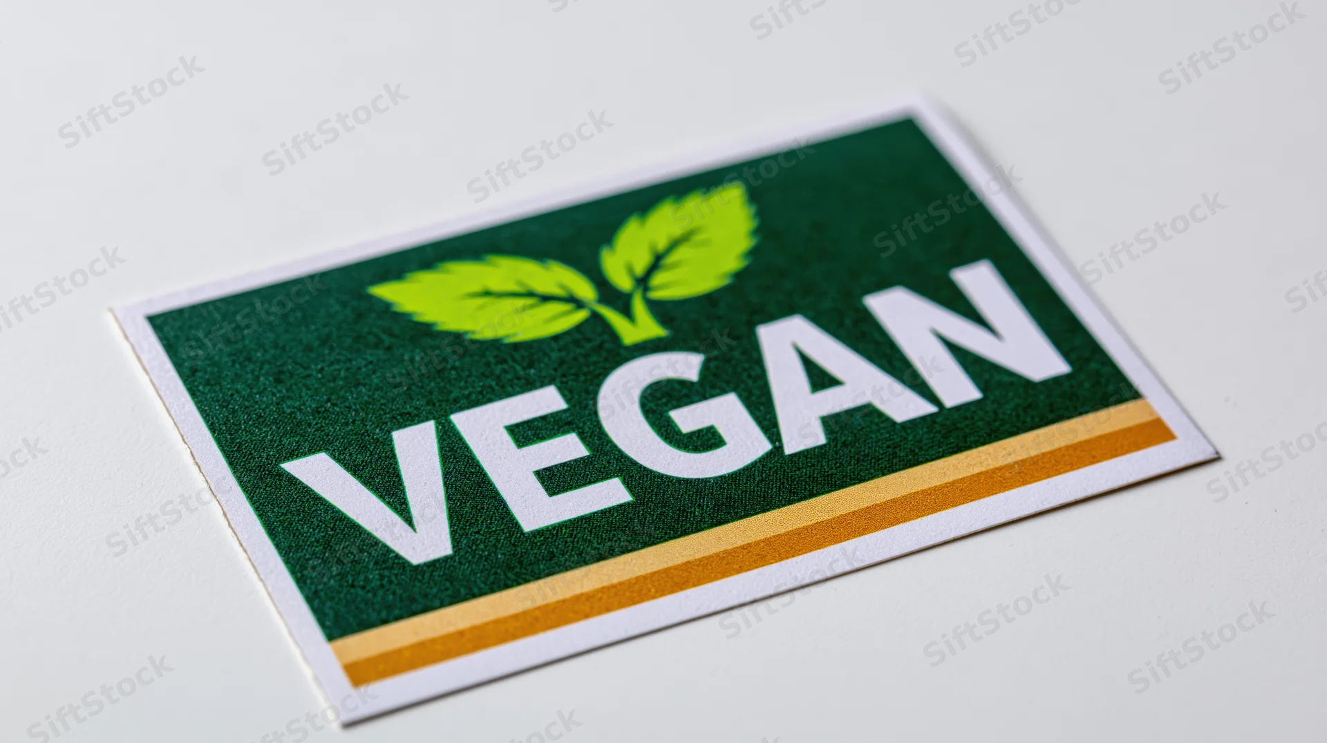 Vegan certification sticker with green leaf logo and white text on white background