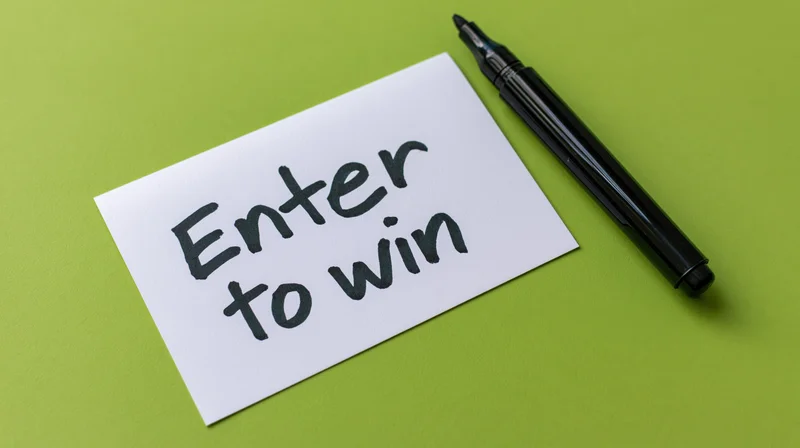 Handwritten note reading enter to win on green surface with black marker beside it