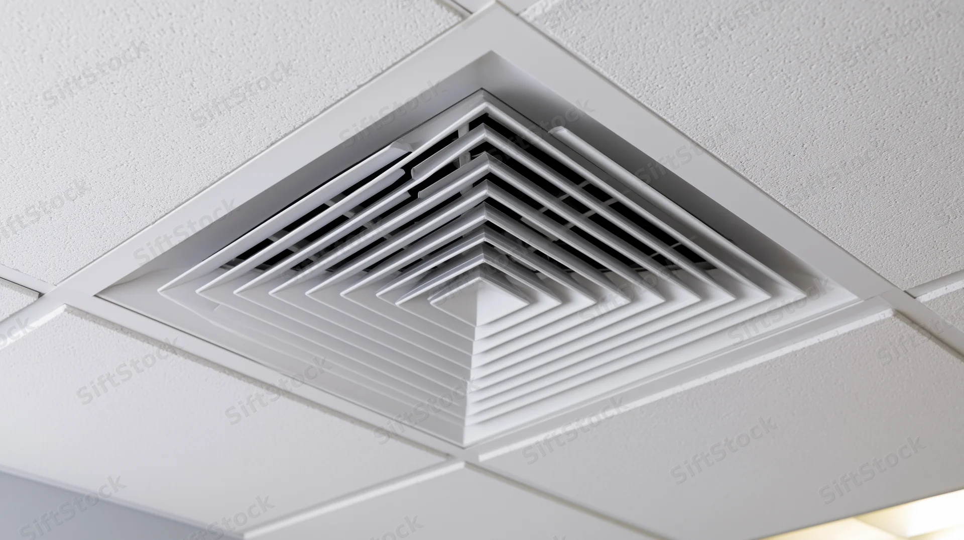 White square hvac ceiling diffuser mounted flush into a suspended ceiling