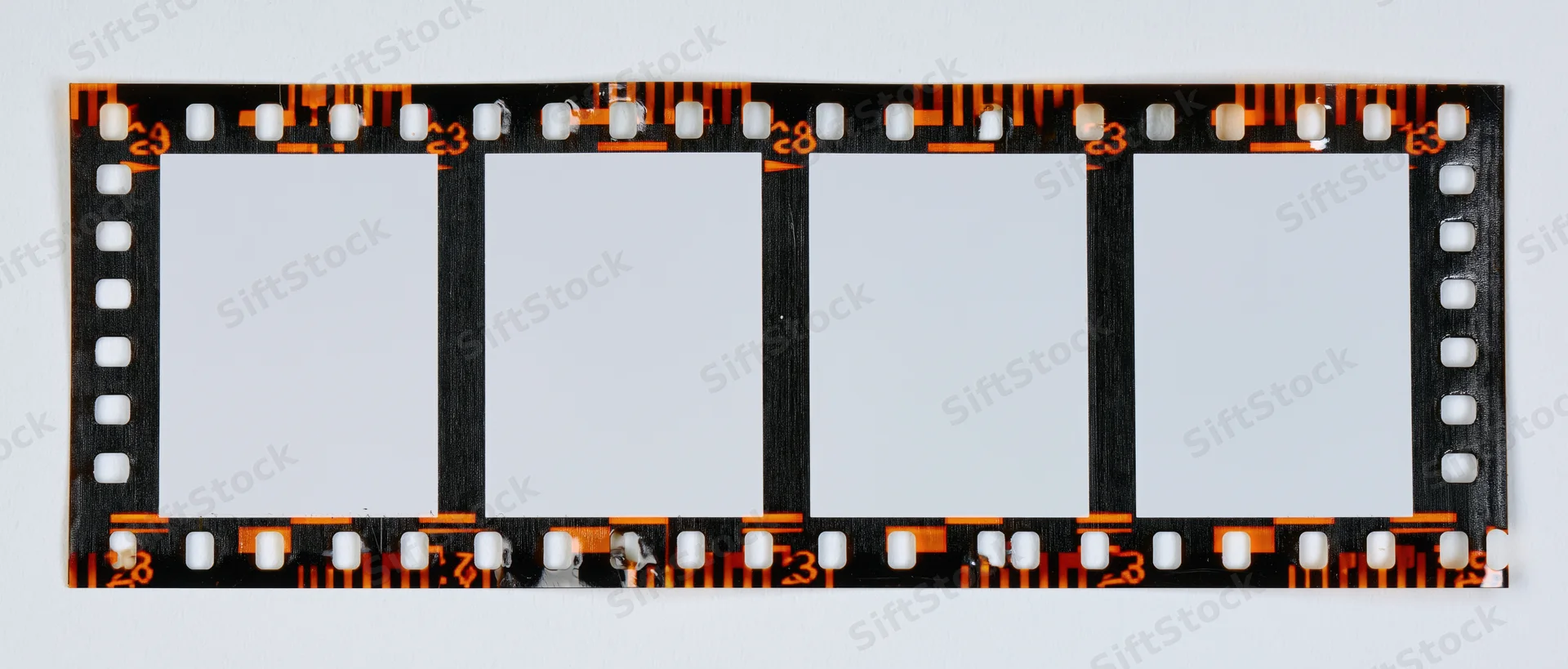 Blank 35mm film strip with four empty frames laid flat on white background