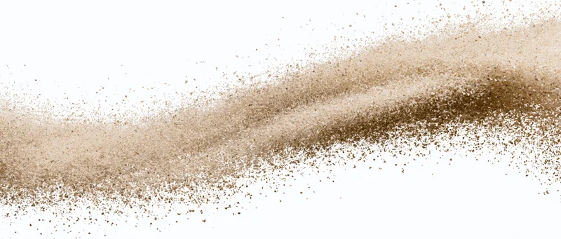 Wave of fine desert sand exploding mid-air scattered particles against white background