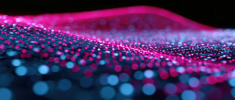 Glowing pink and blue dots arranged in a wavy grid pattern against a dark background