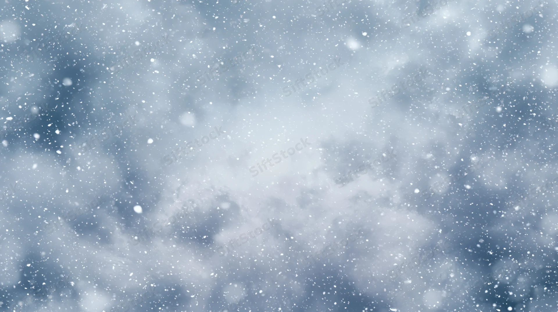 Snowflakes drifting through a cloudy winter sky