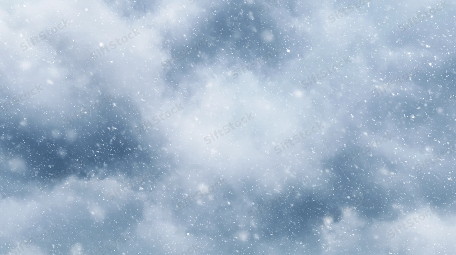 Snow falling against a cloudy winter sky