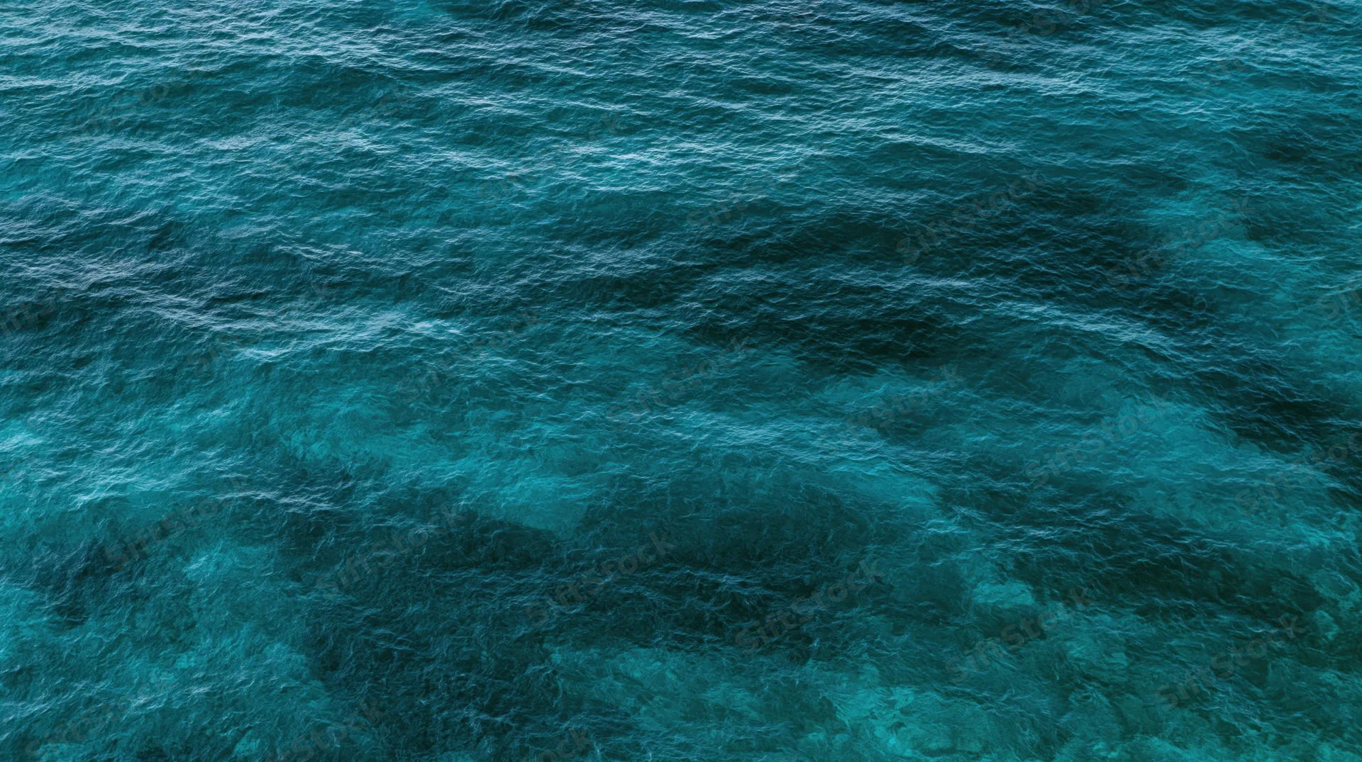 Aerial top-down view of open ocean surface filling the entire frame with rippling blue water