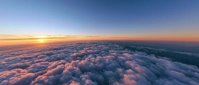 Aerial view above dense cloud layer at sunrise with sun on horizon