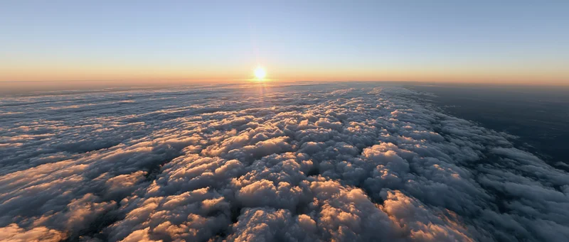 Aerial view of a vast cloud layer at sunrise from high altitude