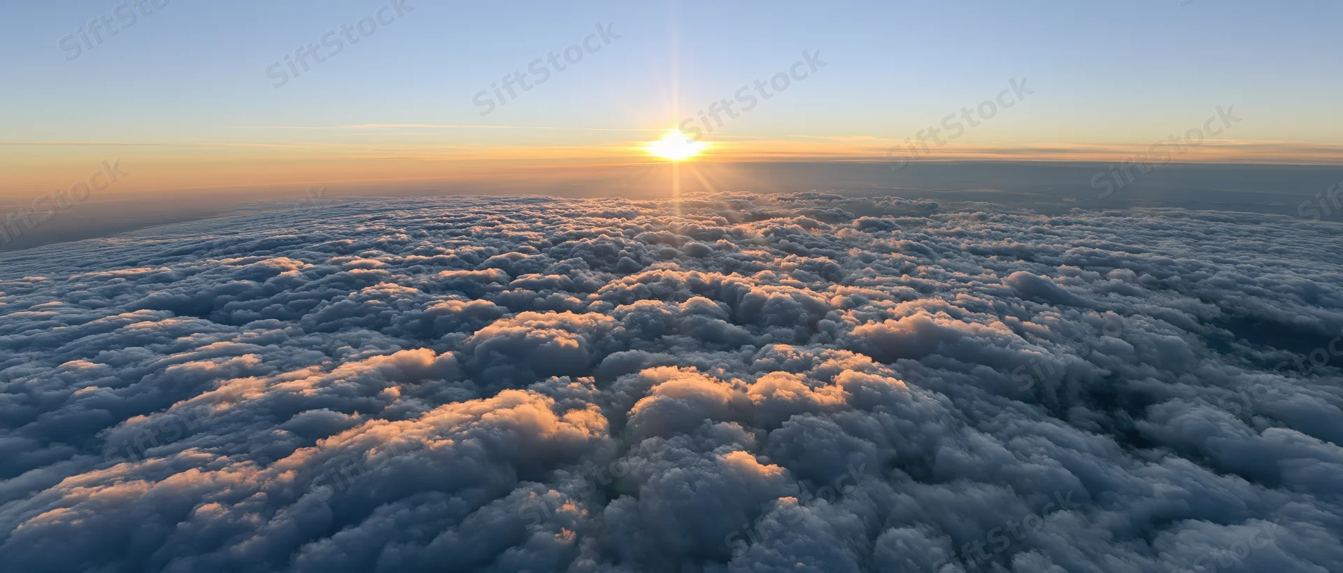 Aerial view of cloudscape at sunrise from above the clouds