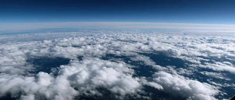 Aerial view of dense white clouds covering the earth below from high altitude