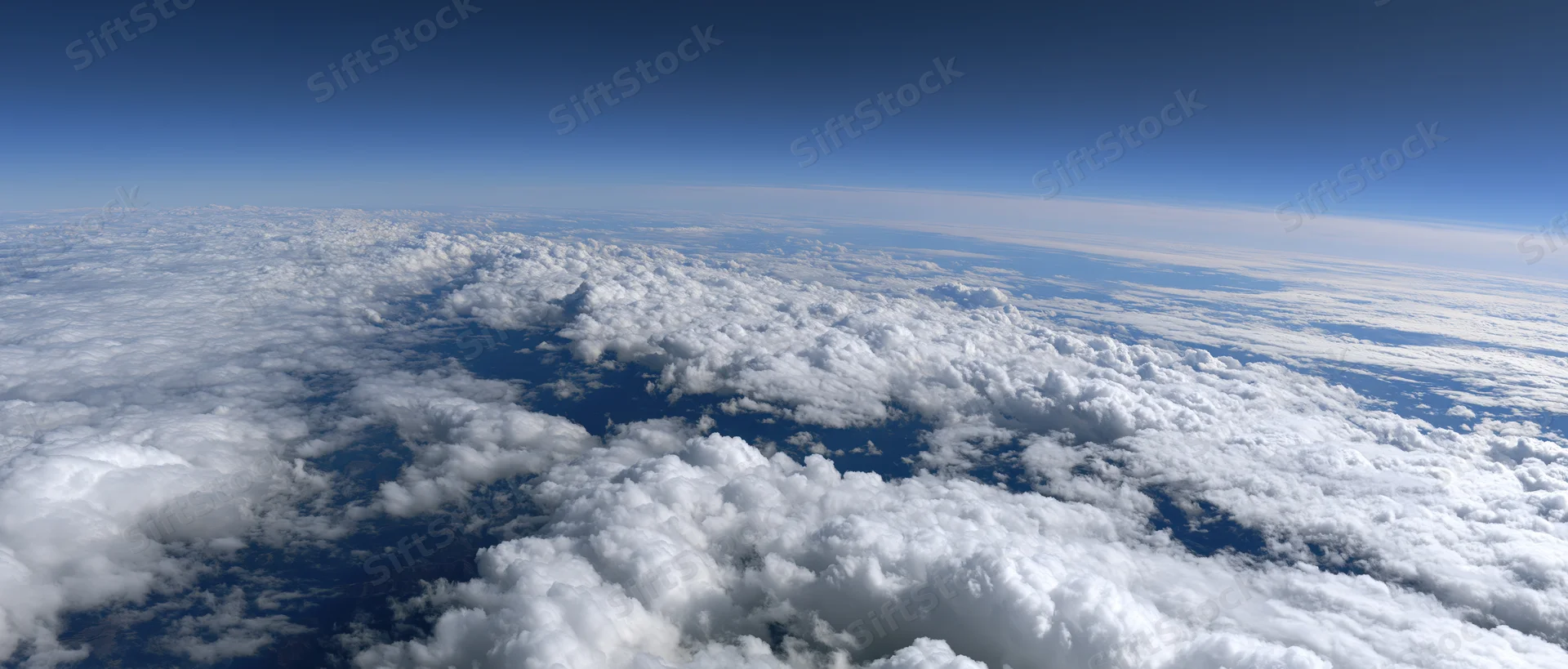 Aerial view of dense white clouds stretching across the sky from high altitude