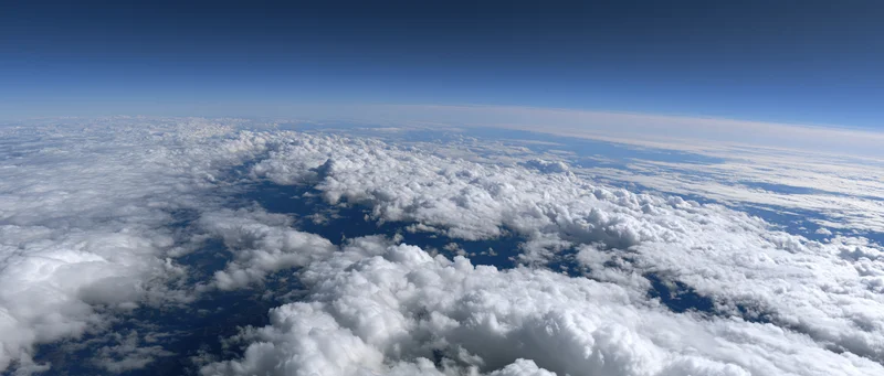 Aerial view of dense white clouds stretching across the sky from high altitude