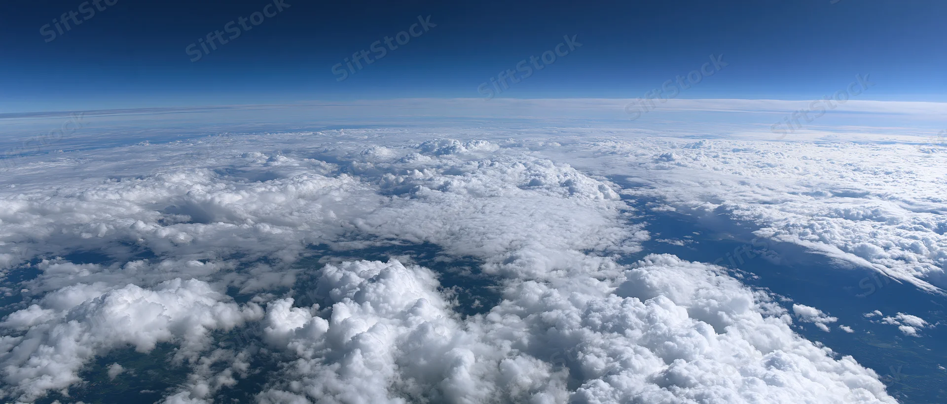 Aerial view of dense white clouds stretching across the sky from high altitude