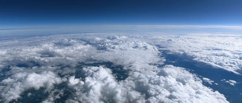 Aerial view of dense white clouds stretching across the sky from high altitude