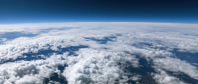 Aerial view of dense white clouds stretching across the sky from high altitude