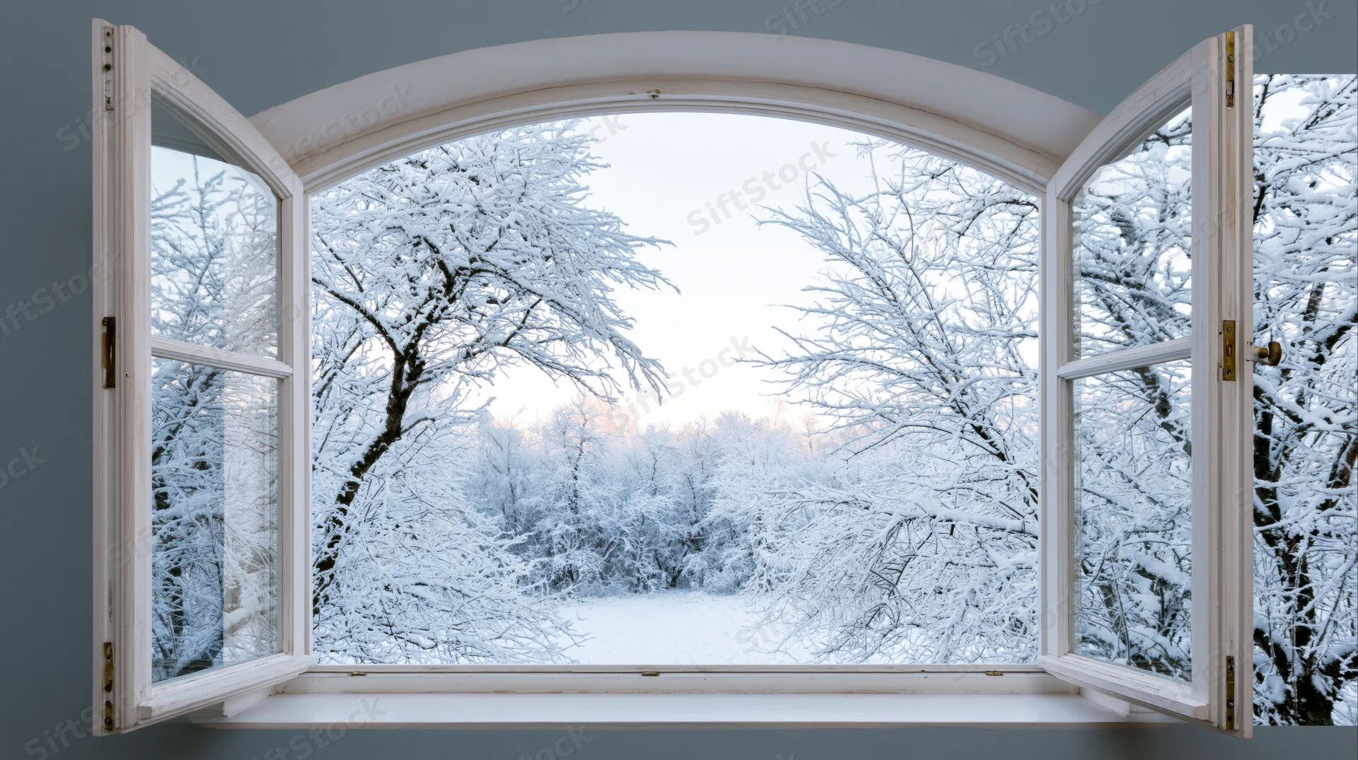 Open arched window framing snow-covered winter forest view from inside a room