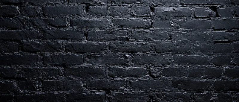 Black-painted brick wall filling the frame as a textured background