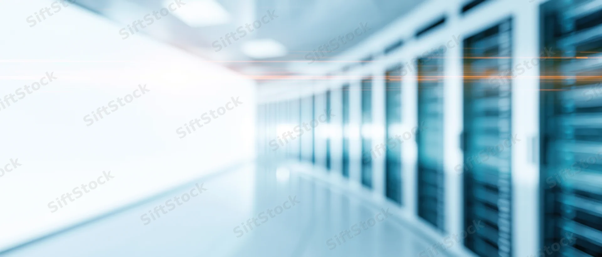 Blurred view of server racks in a datacenter hallway from low wide angle