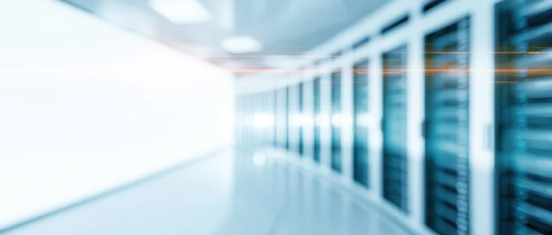 Blurred view of server racks in a datacenter hallway from low wide angle