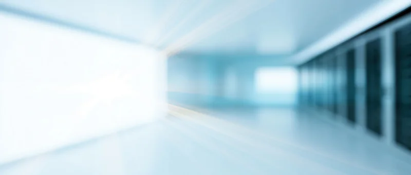 Blurred interior of a server room with rows of racks and bright lighting