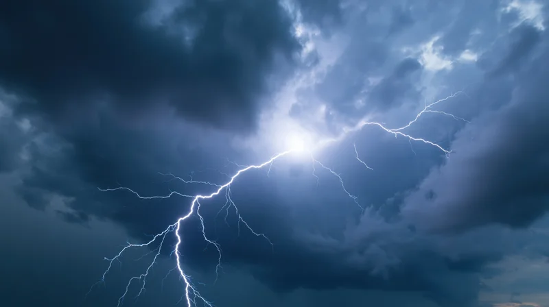 Bright lightning bolt splitting across a dark stormy sky