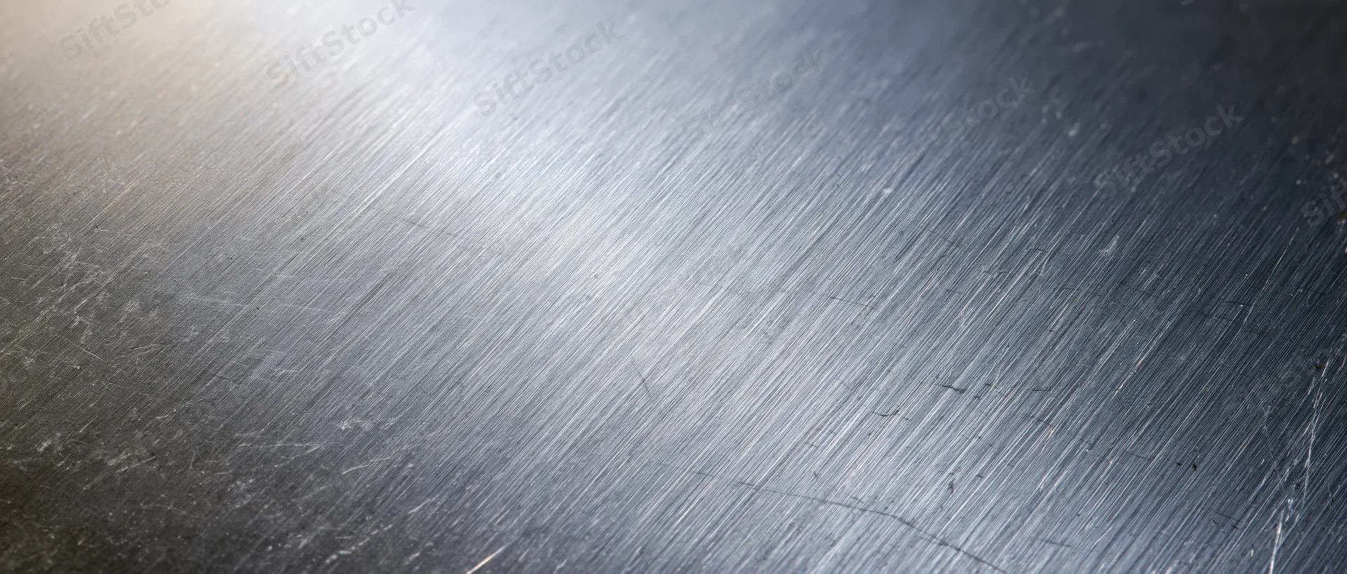 Close-up of brushed stainless steel surface with linear texture and reflective sheen