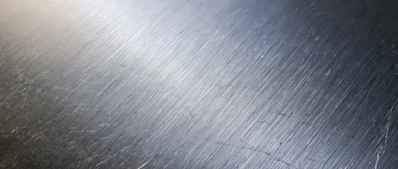 Close-up of brushed stainless steel surface with linear texture and reflective sheen