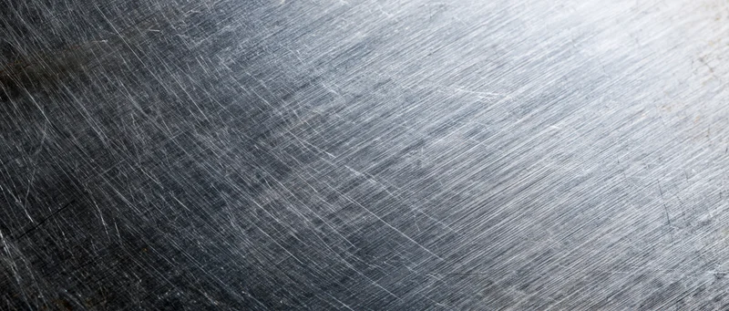 Brushed stainless steel surface with linear texture and metallic sheen filling the frame