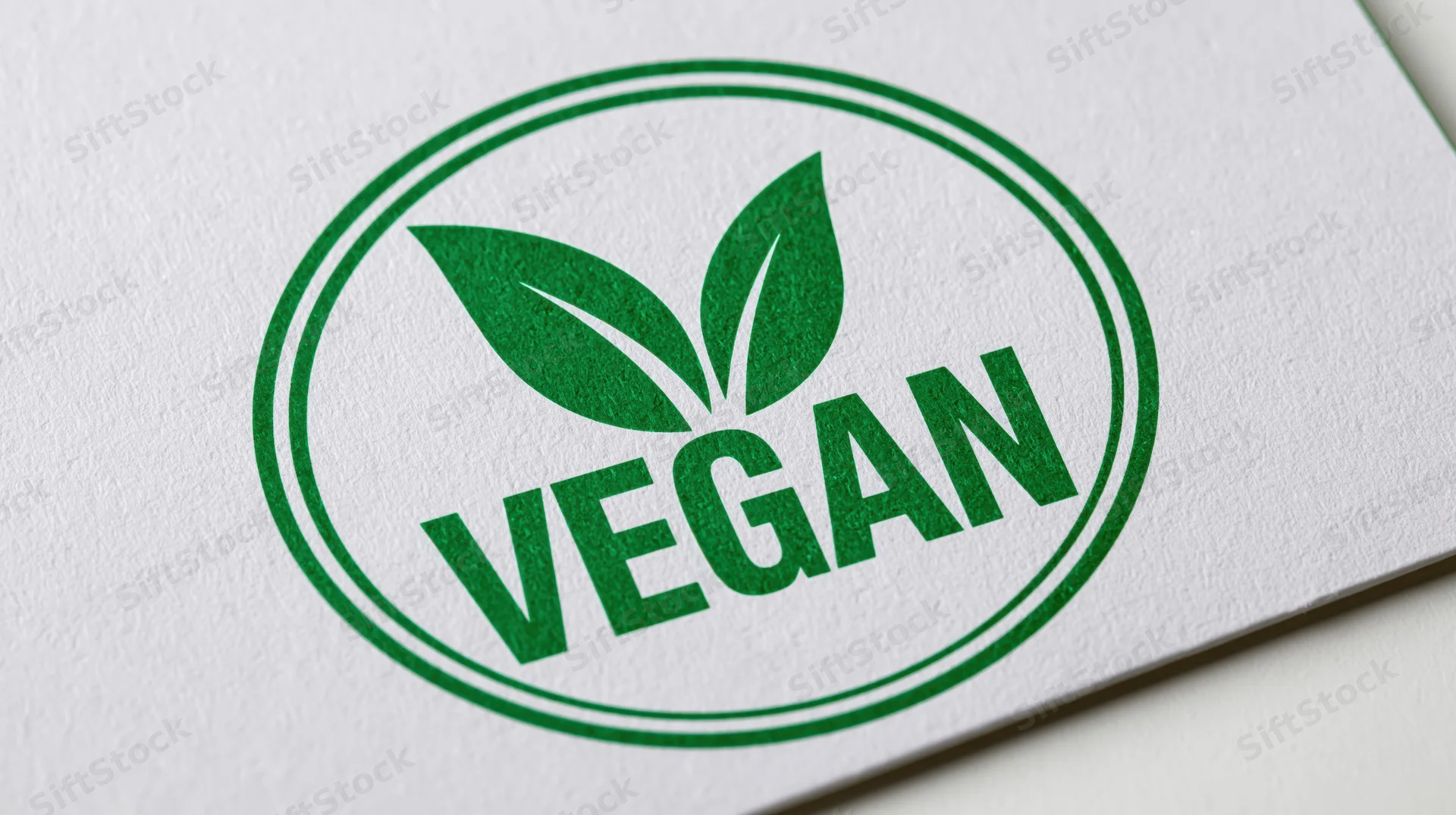 Circular green vegan certification badge printed on white paper