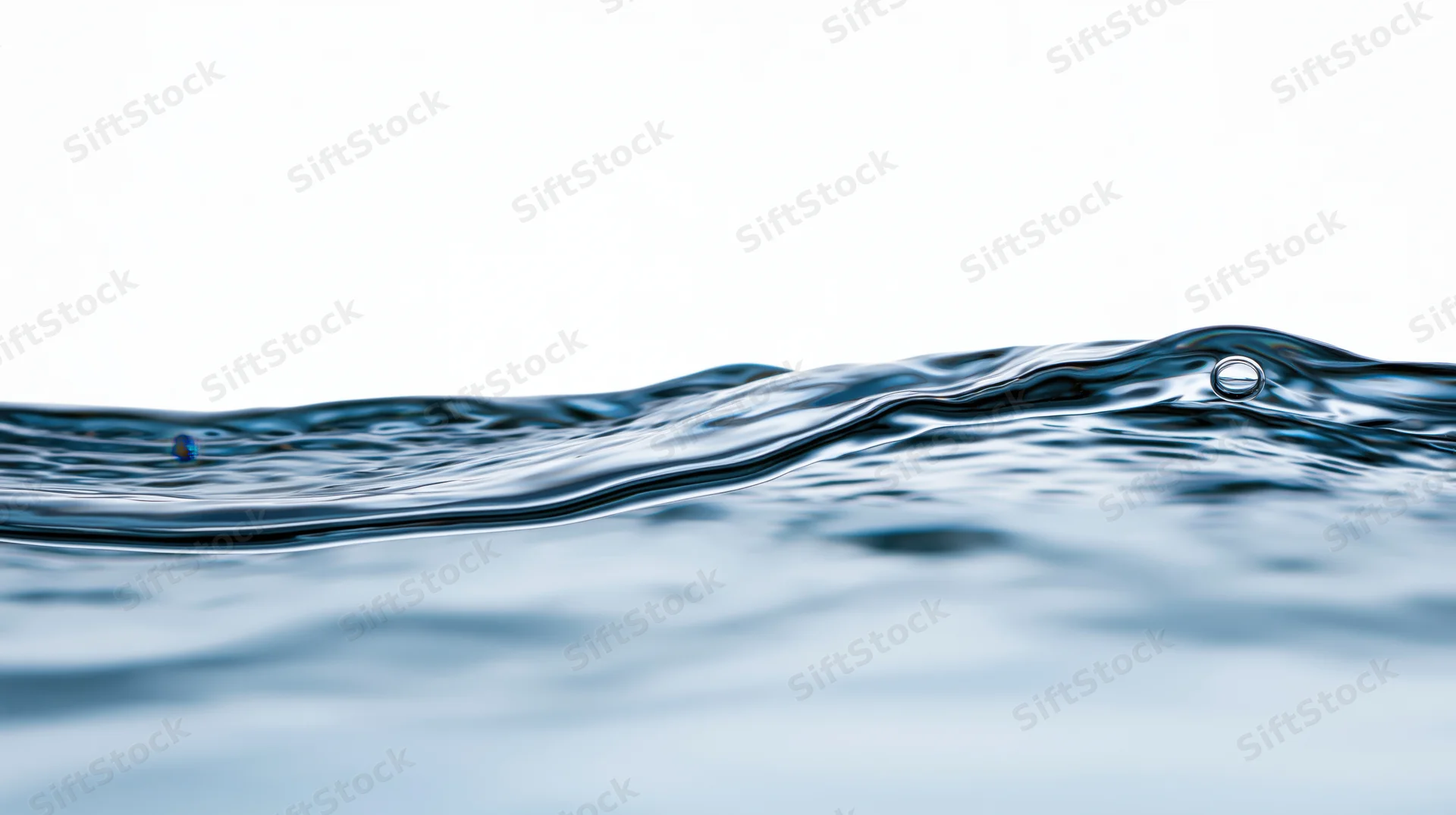 Close-up of rippling water surface with bubbles against white background