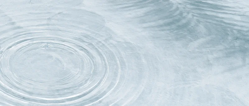 Concentric ripples spreading across a clear shallow water surface viewed from above