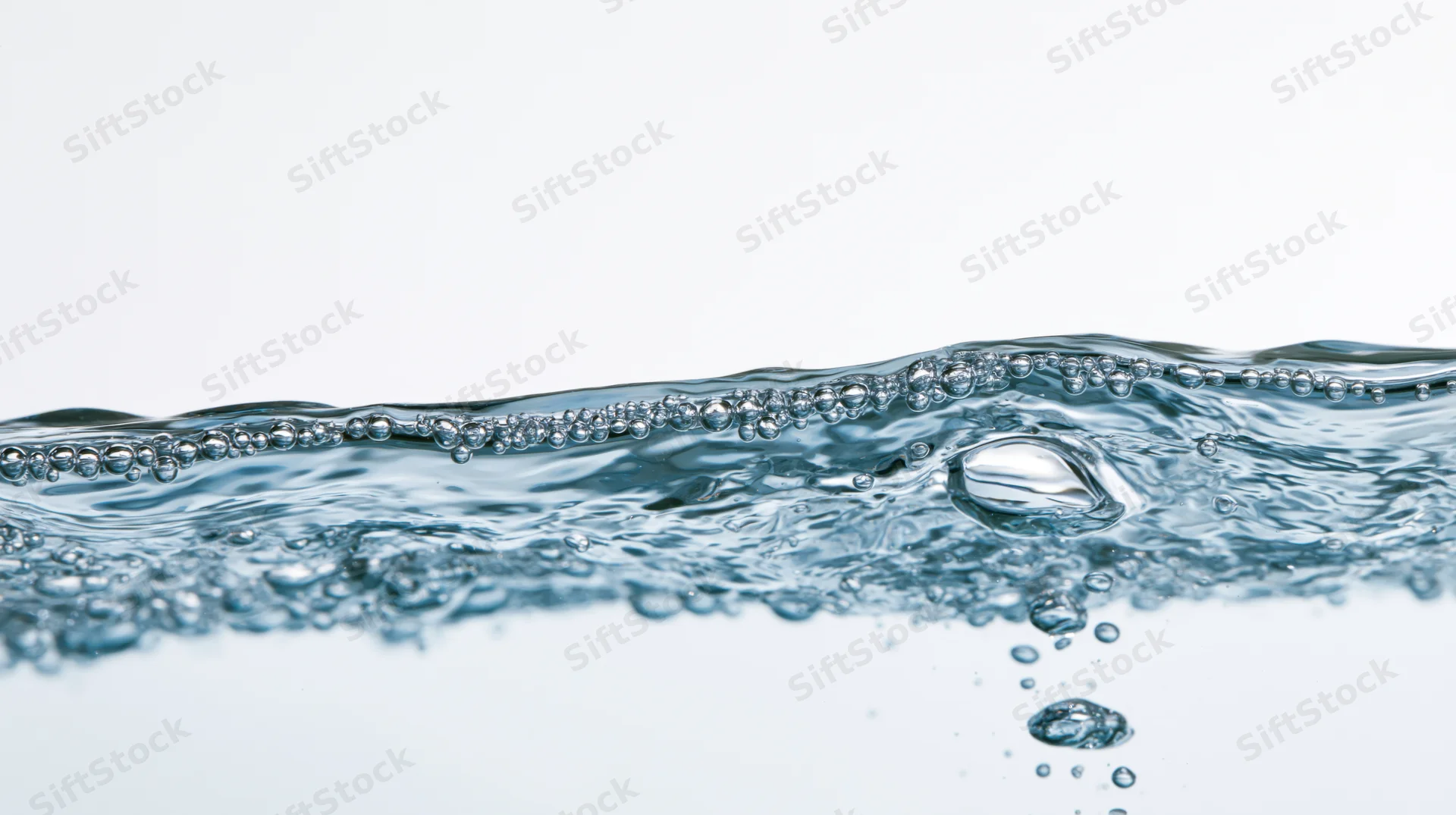 Clear water surface with bubbles and ripples against white background